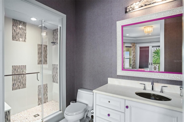 bathroom featuring vanity, toilet, a textured wall, and a stall shower