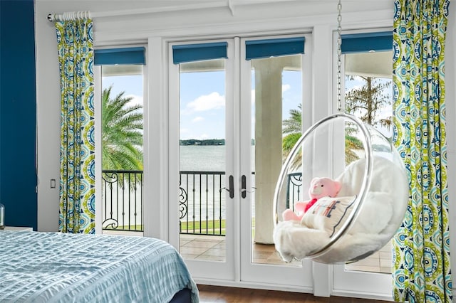 bedroom with french doors, multiple windows, wood finished floors, and access to outside