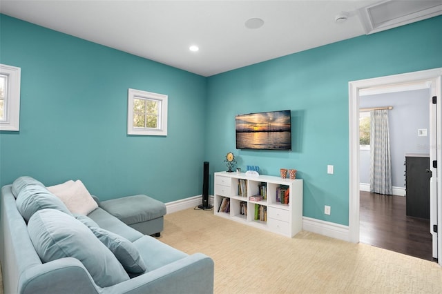 carpeted living area featuring recessed lighting, attic access, and baseboards