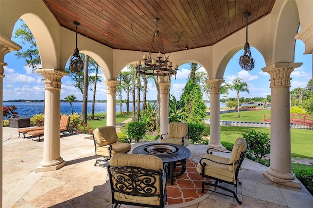 view of patio with a fire pit and a water view