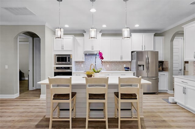 kitchen featuring a kitchen island, white cabinetry, appliances with stainless steel finishes, and pendant lighting