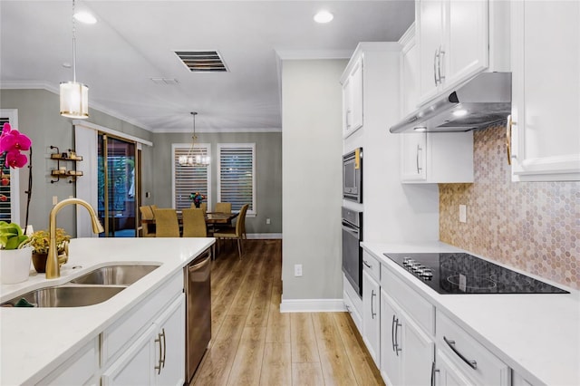 kitchen with white cabinetry, appliances with stainless steel finishes, sink, and hanging light fixtures