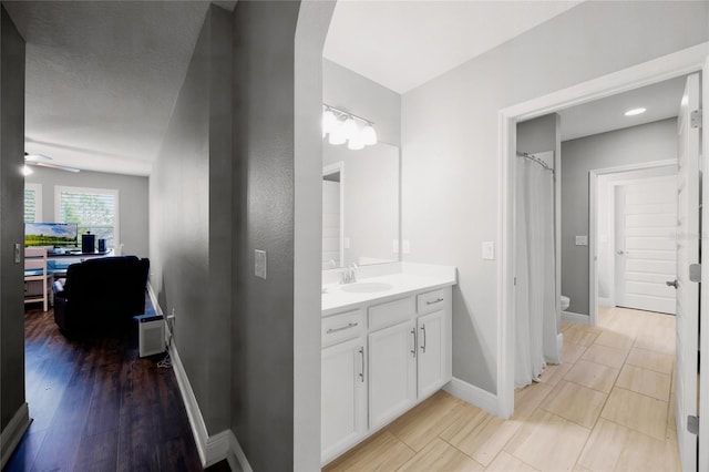 bathroom with vanity, ceiling fan, wood-type flooring, and toilet