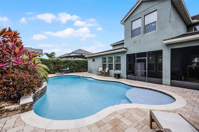 view of swimming pool featuring a sunroom and a patio