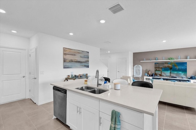 kitchen with sink, light tile patterned floors, white cabinetry, an island with sink, and stainless steel dishwasher