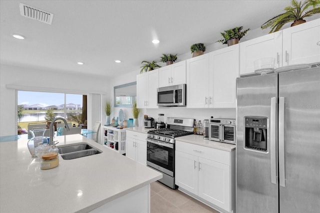 kitchen featuring white cabinetry, appliances with stainless steel finishes, sink, and light tile patterned floors