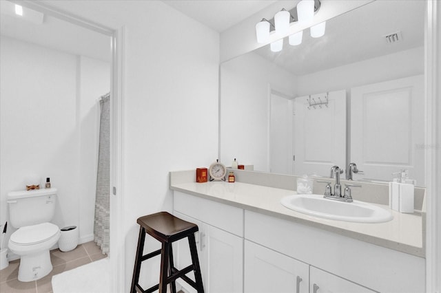 bathroom with vanity, toilet, curtained shower, and tile patterned flooring