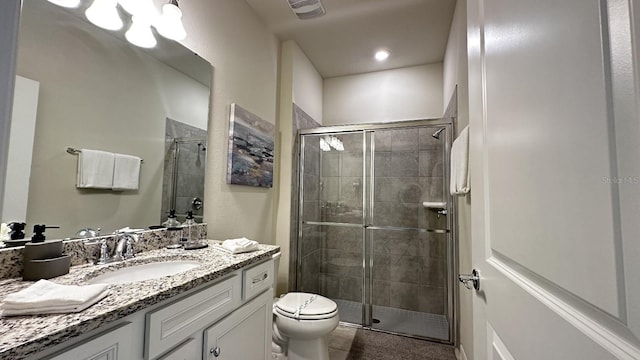 bathroom with vanity, tile patterned floors, a shower with door, and toilet