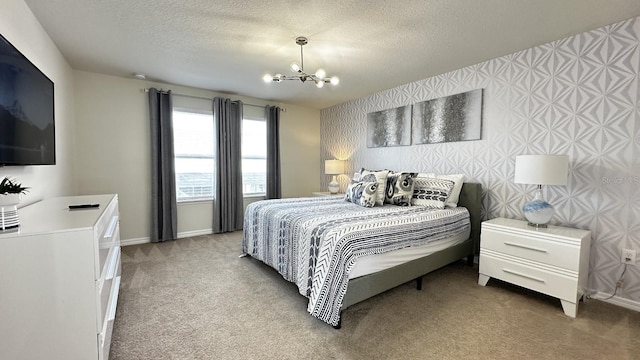 bedroom featuring carpet floors, a textured ceiling, and an inviting chandelier