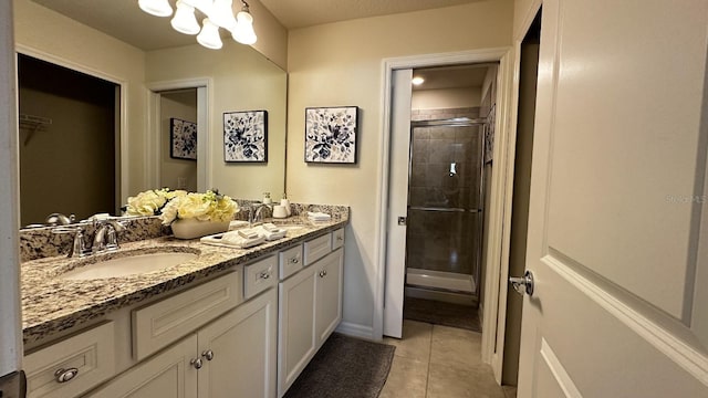 bathroom featuring tile patterned flooring, vanity, and walk in shower