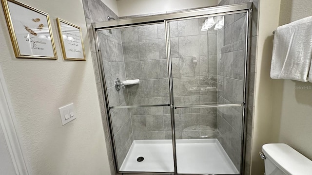 bathroom featuring walk in shower and toilet