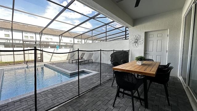 view of pool featuring a patio area, ceiling fan, and glass enclosure