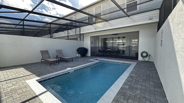 view of swimming pool with a patio and a lanai