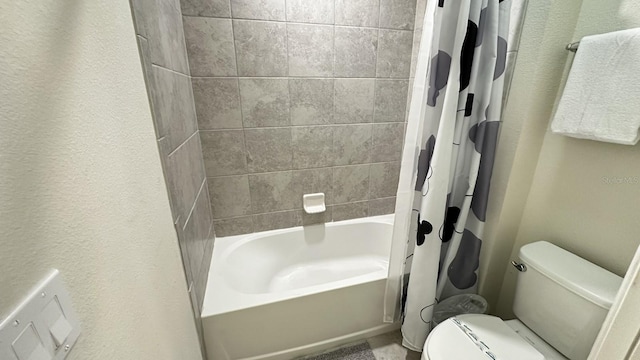 bathroom featuring shower / bathtub combination with curtain and toilet