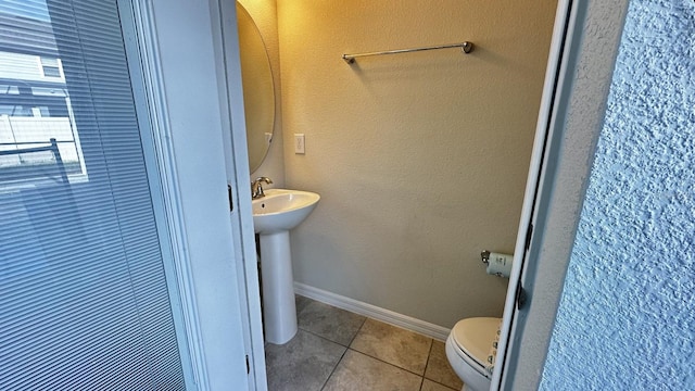 bathroom featuring sink, toilet, and tile patterned flooring