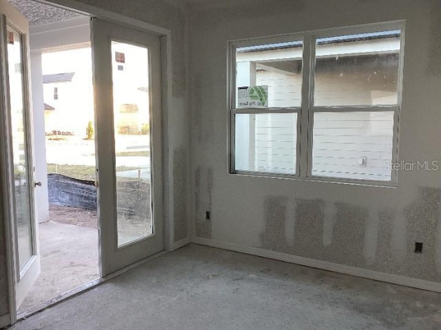 doorway with a healthy amount of sunlight and concrete floors