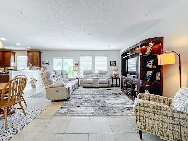 living room featuring a textured ceiling and light tile patterned floors