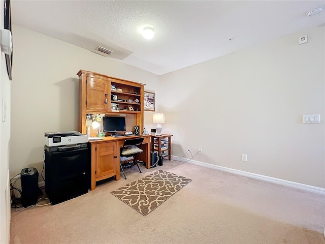 office space featuring light carpet and a textured ceiling