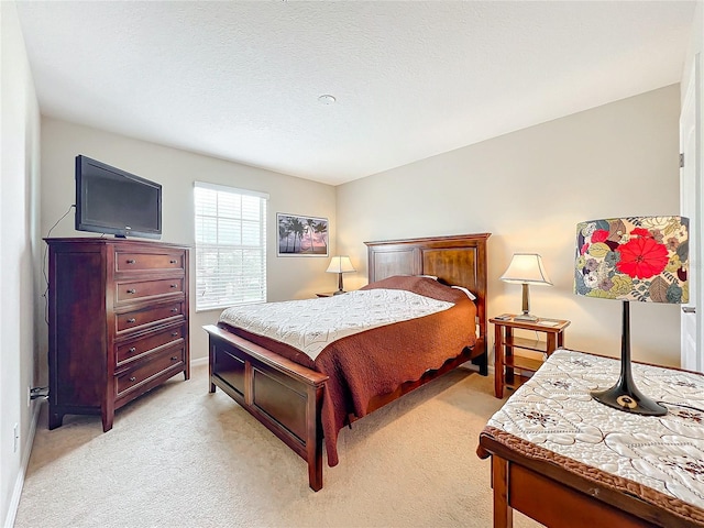 bedroom with light colored carpet and a textured ceiling