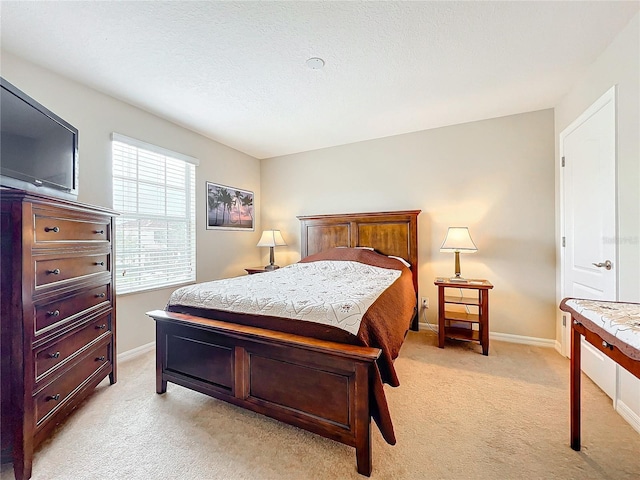 bedroom featuring light colored carpet and a textured ceiling