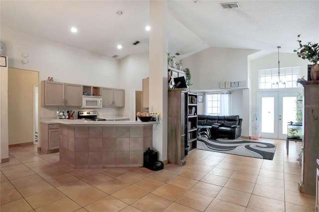 kitchen featuring light tile patterned floors, stainless steel range with electric cooktop, high vaulted ceiling, and kitchen peninsula