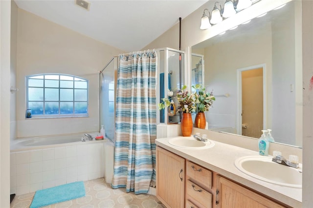 bathroom featuring lofted ceiling, a sink, a bath, and double vanity