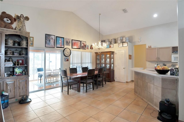 dining area featuring high vaulted ceiling, a chandelier, light tile patterned flooring, and visible vents