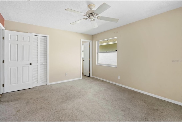 unfurnished bedroom with light colored carpet, a closet, and ceiling fan