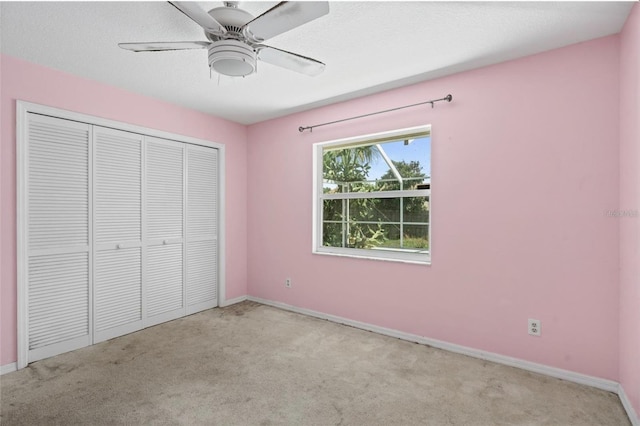 unfurnished bedroom with light carpet, ceiling fan, and a closet