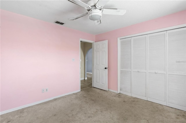 unfurnished bedroom with light carpet, a closet, and ceiling fan