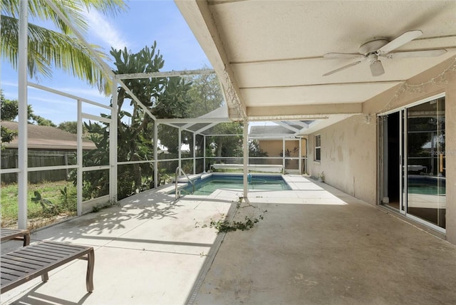 view of swimming pool with ceiling fan, a lanai, and a patio area