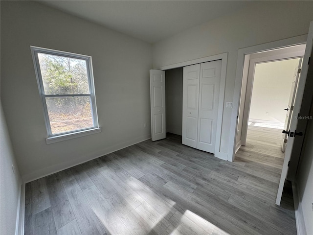 unfurnished bedroom featuring light hardwood / wood-style floors and a closet