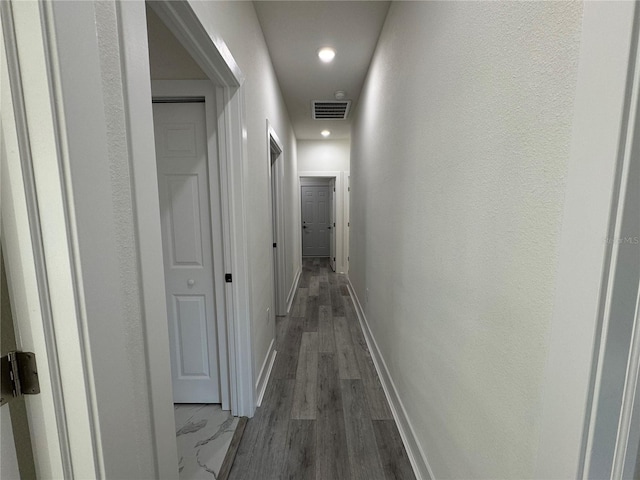 hallway with dark hardwood / wood-style flooring