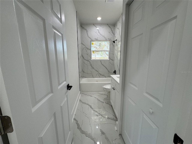 full bathroom featuring tiled shower / bath, vanity, and toilet