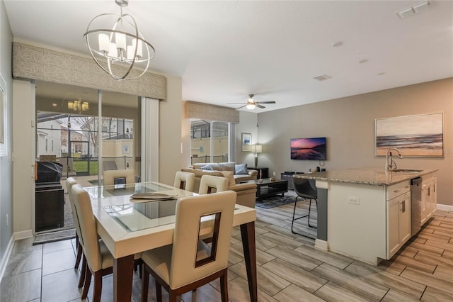 dining room with sink and ceiling fan with notable chandelier