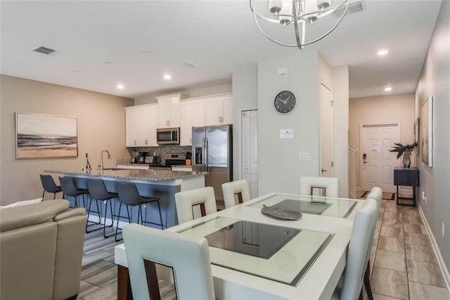 dining room with a chandelier and sink