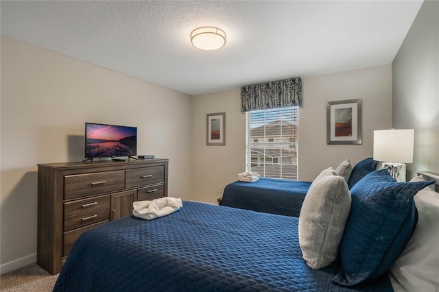 carpeted bedroom featuring a textured ceiling