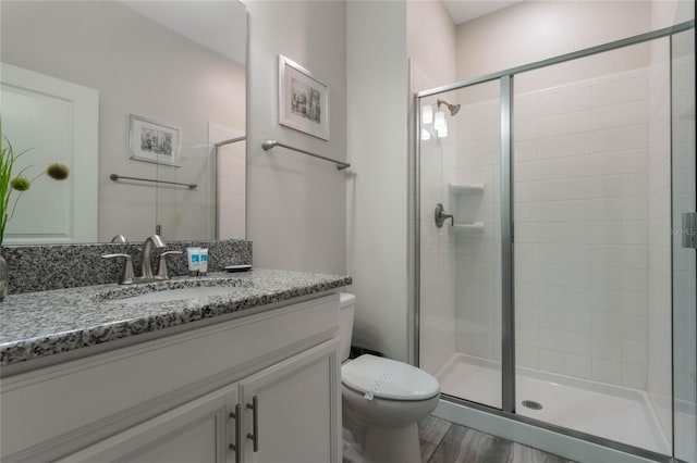 bathroom featuring vanity, toilet, an enclosed shower, and wood-type flooring