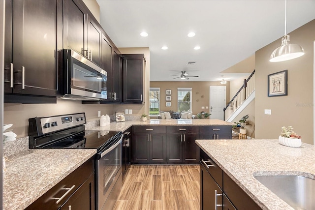 kitchen with hanging light fixtures, dark brown cabinets, and stainless steel appliances