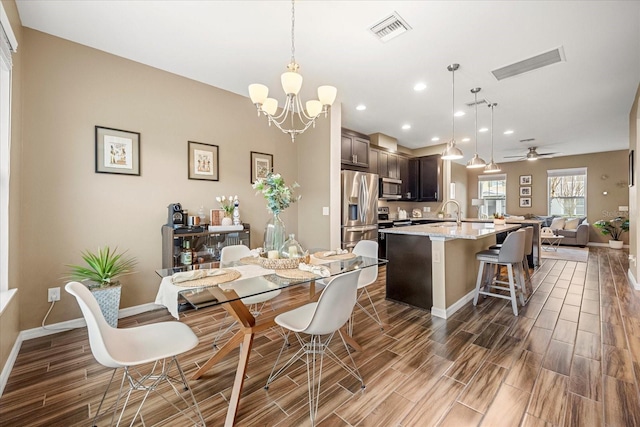 dining area featuring ceiling fan with notable chandelier