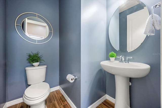 bathroom featuring wood-type flooring and toilet