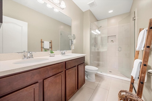 bathroom with a shower with door, vanity, tile patterned floors, and toilet