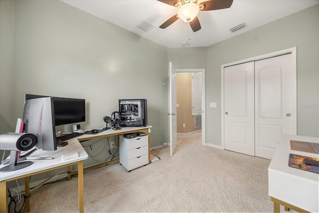 carpeted home office featuring ceiling fan