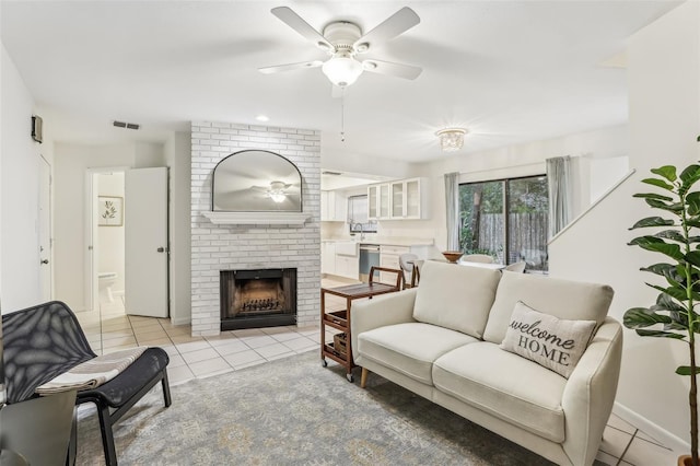 tiled living room with ceiling fan and a fireplace