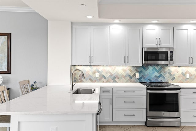 kitchen featuring stainless steel appliances, light tile patterned floors, white cabinets, and kitchen peninsula