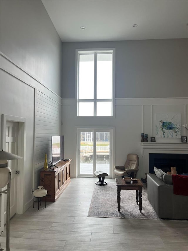 living room featuring a high ceiling and light hardwood / wood-style flooring