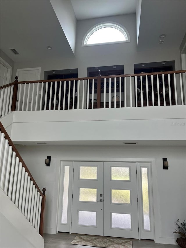 foyer entrance with french doors and a towering ceiling