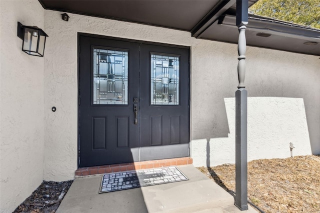 entrance to property with stucco siding