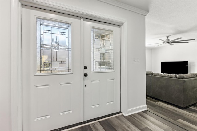 entrance foyer with dark wood-style floors, ceiling fan, crown molding, and baseboards