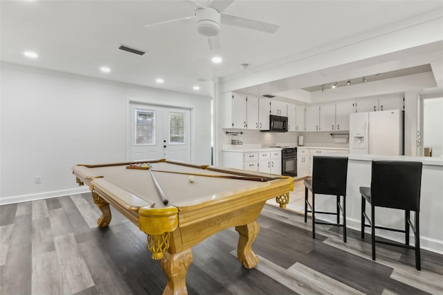 rec room with dark wood-style floors, visible vents, crown molding, and baseboards